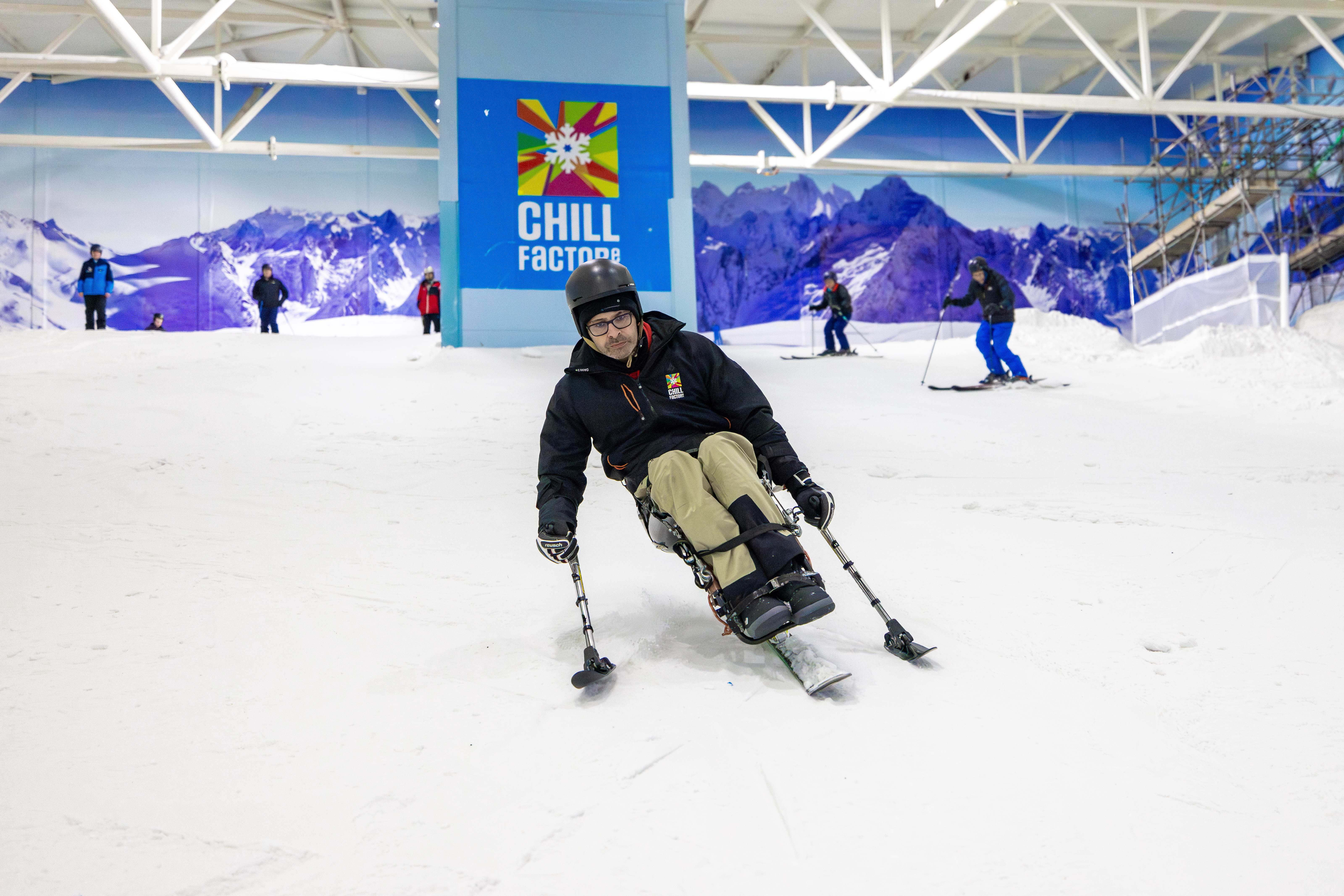 Sit skier, mid run on an indoor snow slope