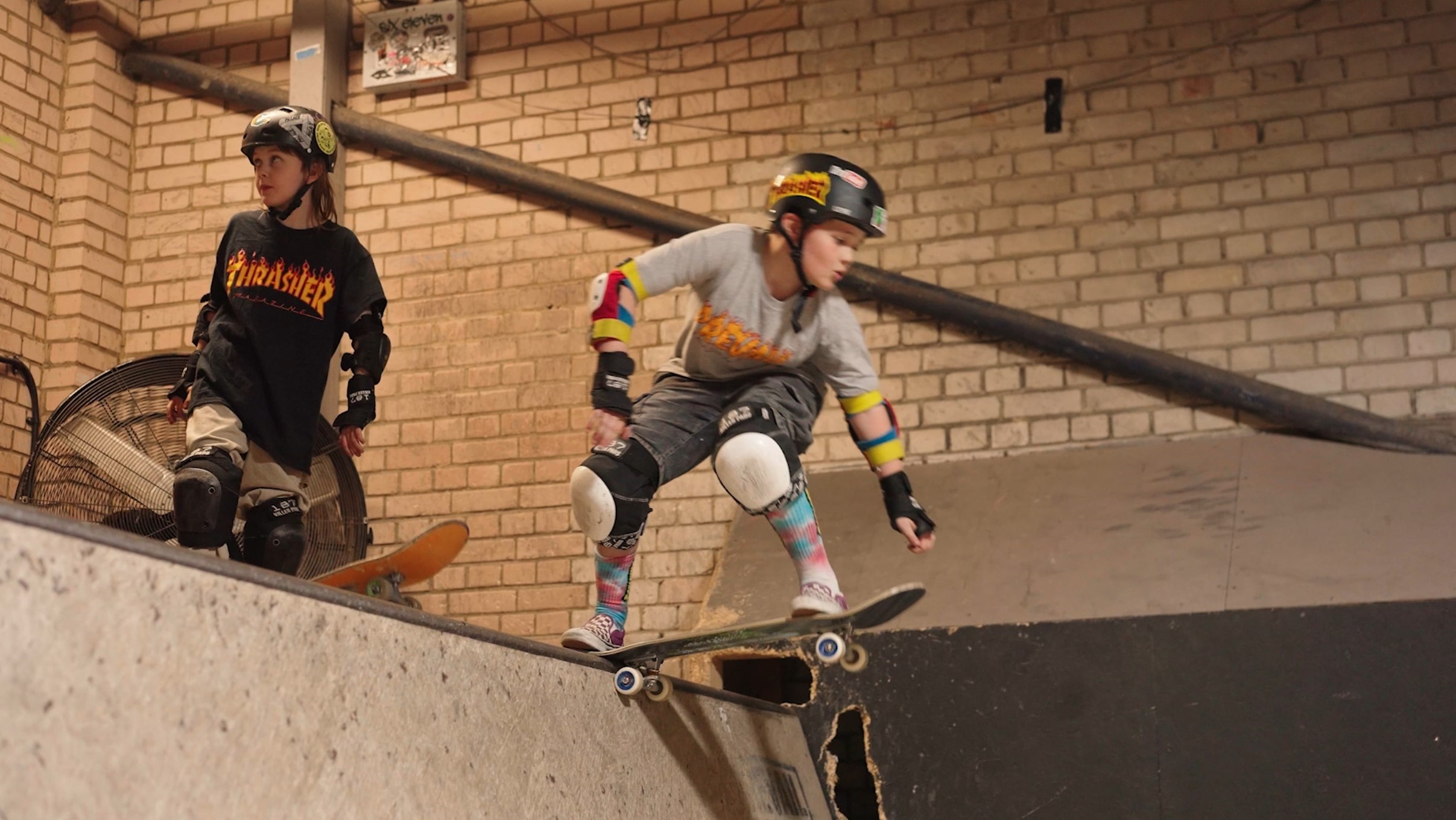 Adaptive skateboarder ready to drop in on an indoor bowl.
