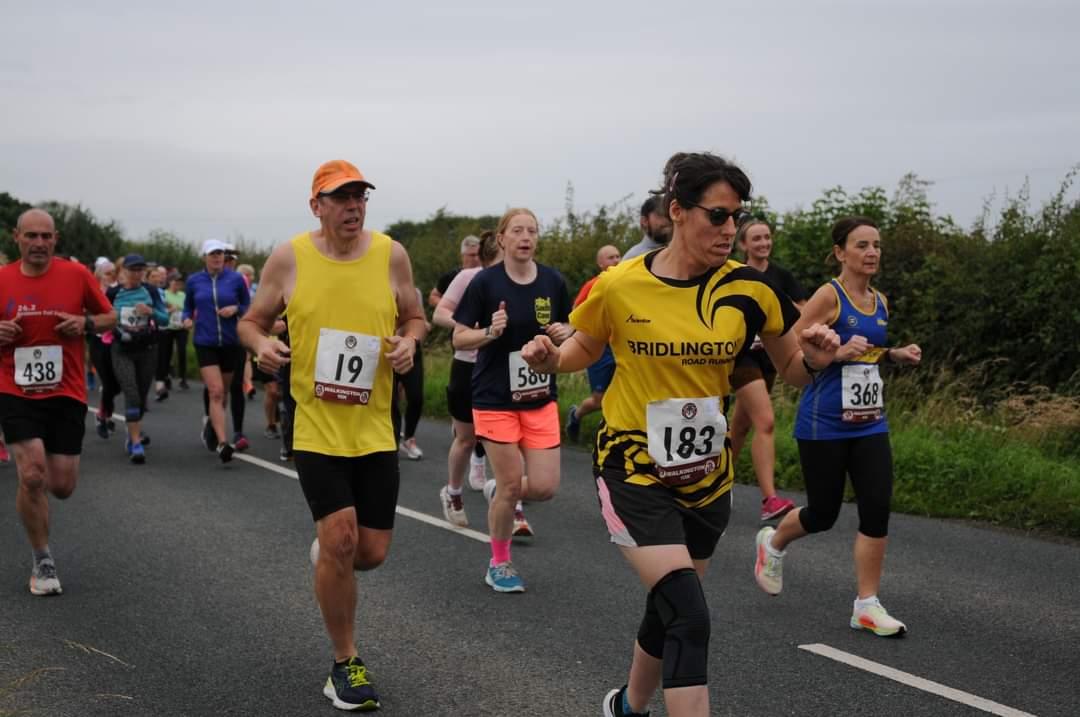 Nicola Fowler running wearing a yellow and black top