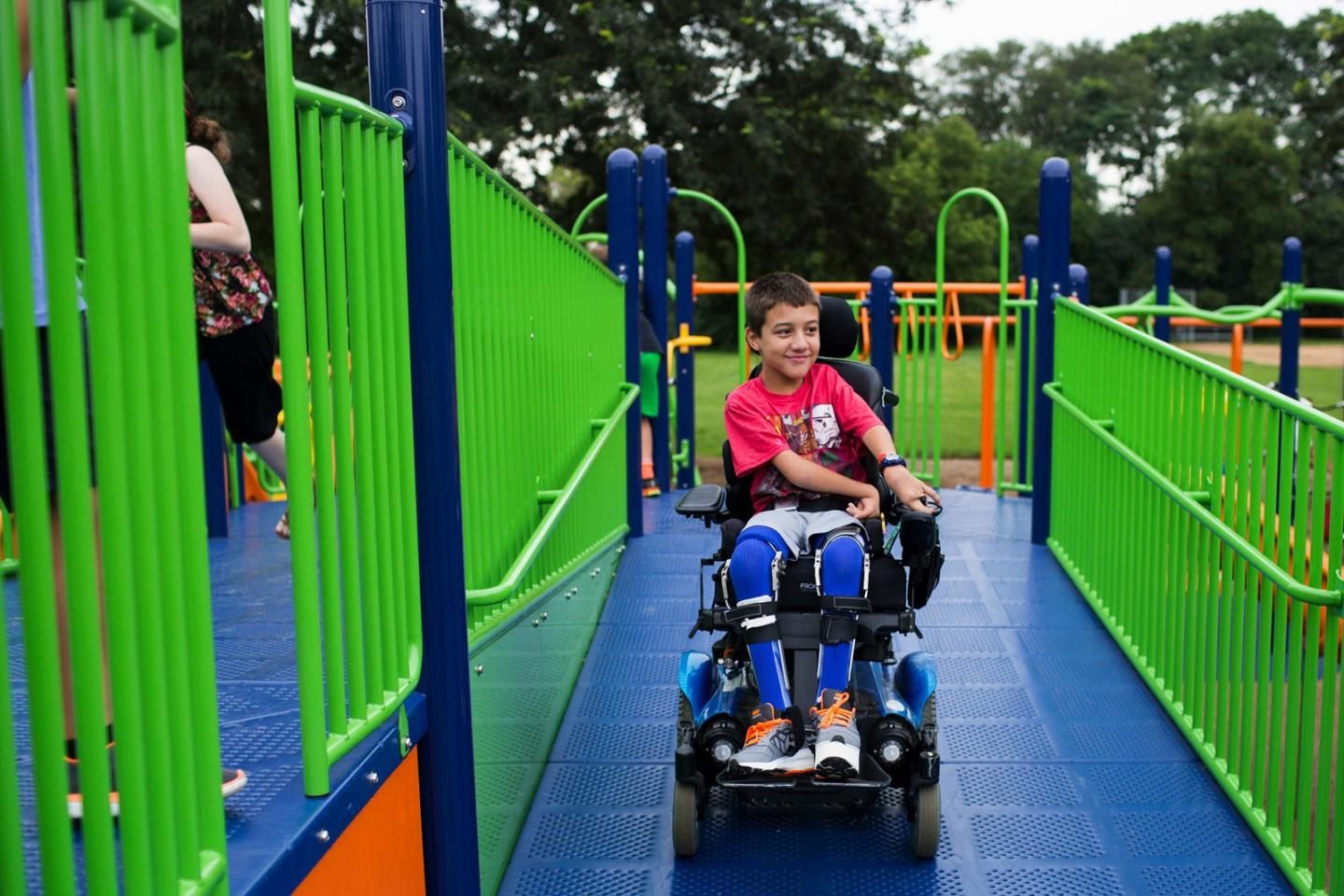 A boy in a wheelchair using an accessible climbing frame