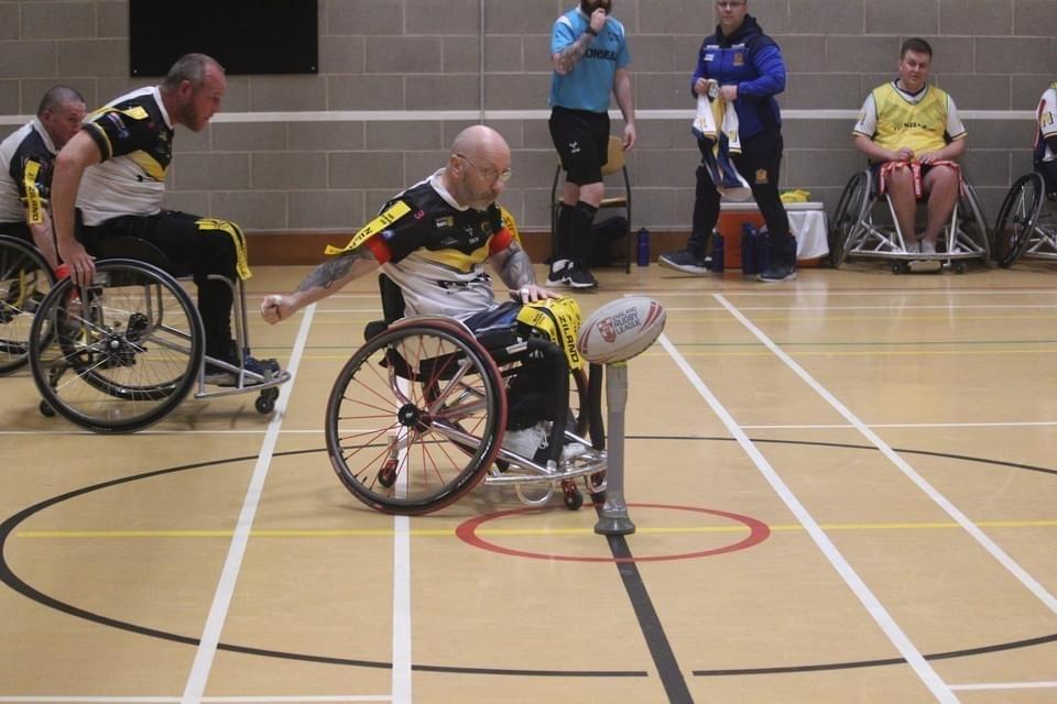 Stewart Walker starts a wheelchair rugby league game by punching the ball off the tee