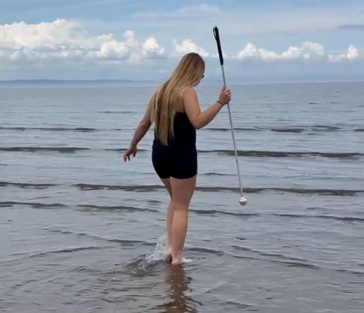 Young person paddling in shallow water on the beach