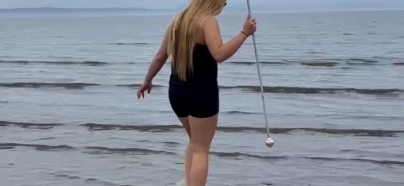 Young person paddling in shallow water on the beach