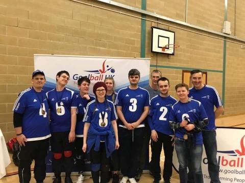 Players in playing shirts collecting medals after a tournament