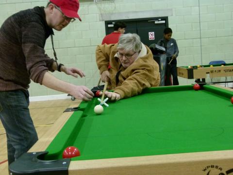 Two older participants playing snooker