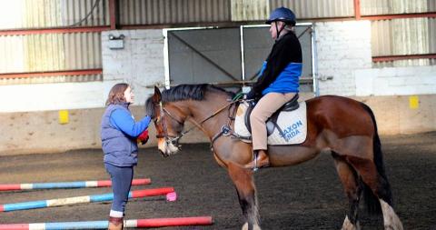 One of our coaches talking to a rider sitting on a horse