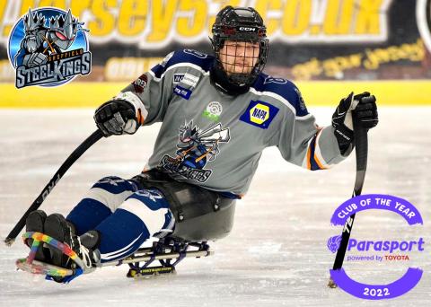 sheffield steelkings male para ice hockey player, in sledge on ice, holding sitcks and mid turn