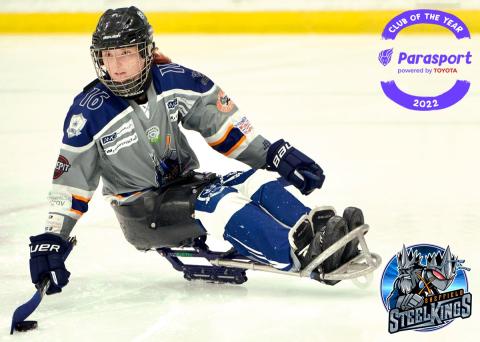 Female Sheffield Steelkings para ice hockey player, in her sledge on ice, holding poles and dribbling the puck