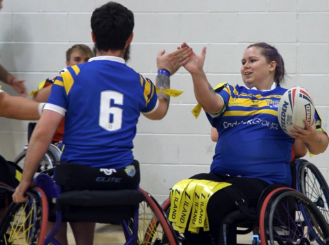 wheel chair rugby league players giving a high 5