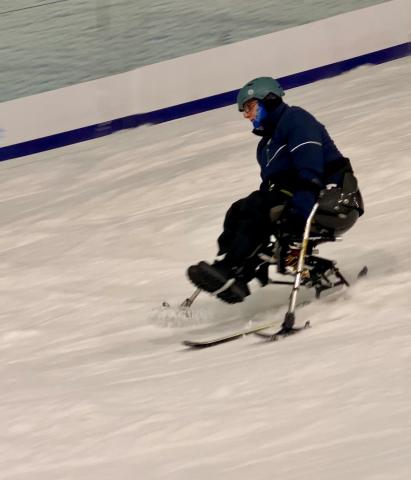 sit skier, mid run, on an indoor ski slope