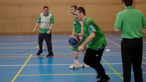 BISA particpants playing basketball on an indoor sports hall court.