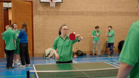 BISA participant playing table tennis in an indoor sports hall