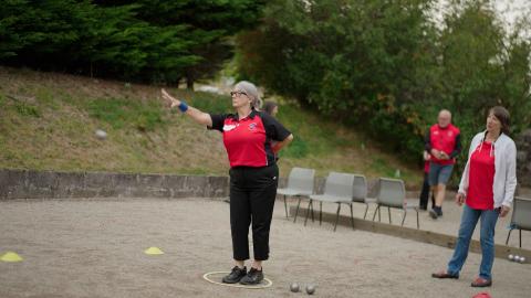 Female petanque player mid throw