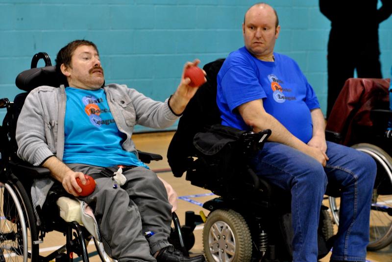 A participant throwing a ball whilst an opponent watches