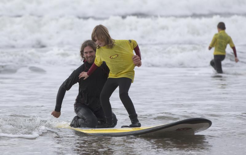 A visually impaired surfer, surfing tandem with a Surfability coach