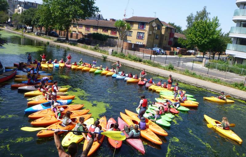 Here is a group of around 40 young people playing a game in their kayaks, in the sun, where they run across each others boats.