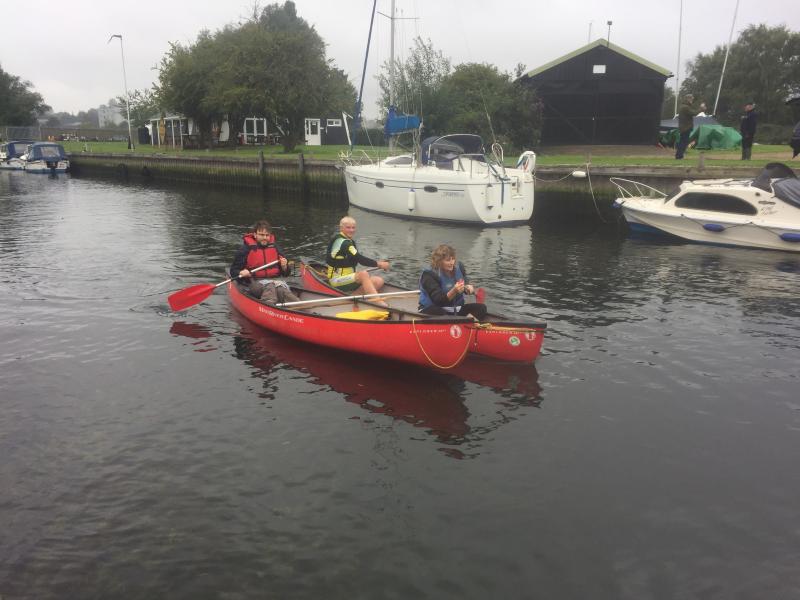 Disabled paddlers paddling a Canadian Canoe down a river