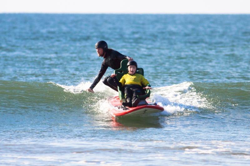 Riding a wave on our seated tandem surfboard for wheelchair users