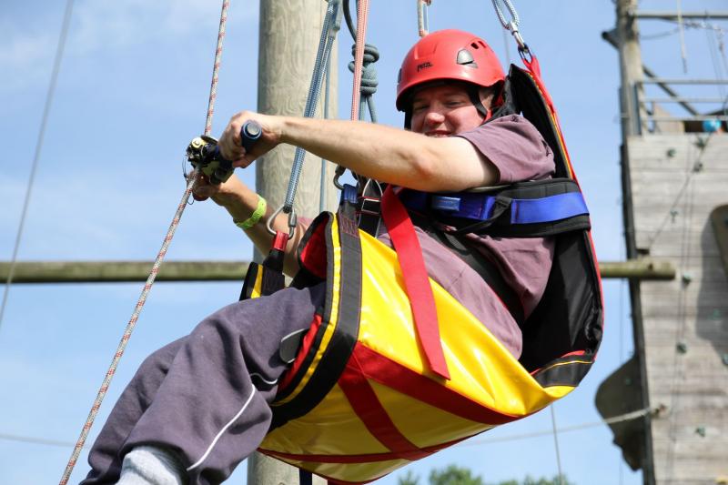 young boy in high ropes harness 