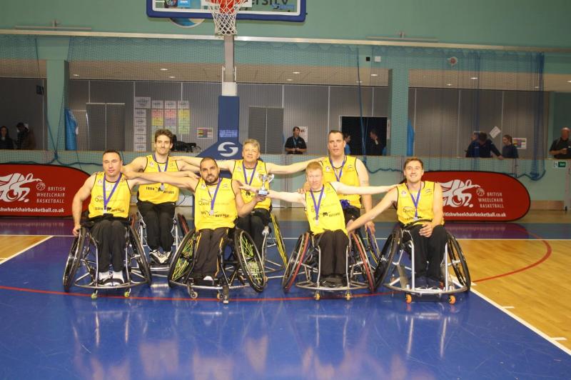 team photo of Essex Outlaws Wheelchair Basketball with trophy