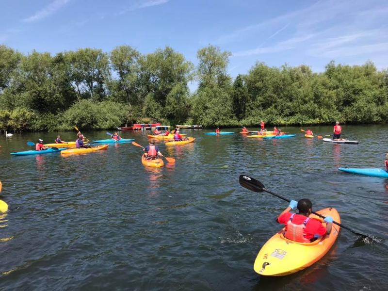 A group of sit-on-top and closed cockpit kayaks