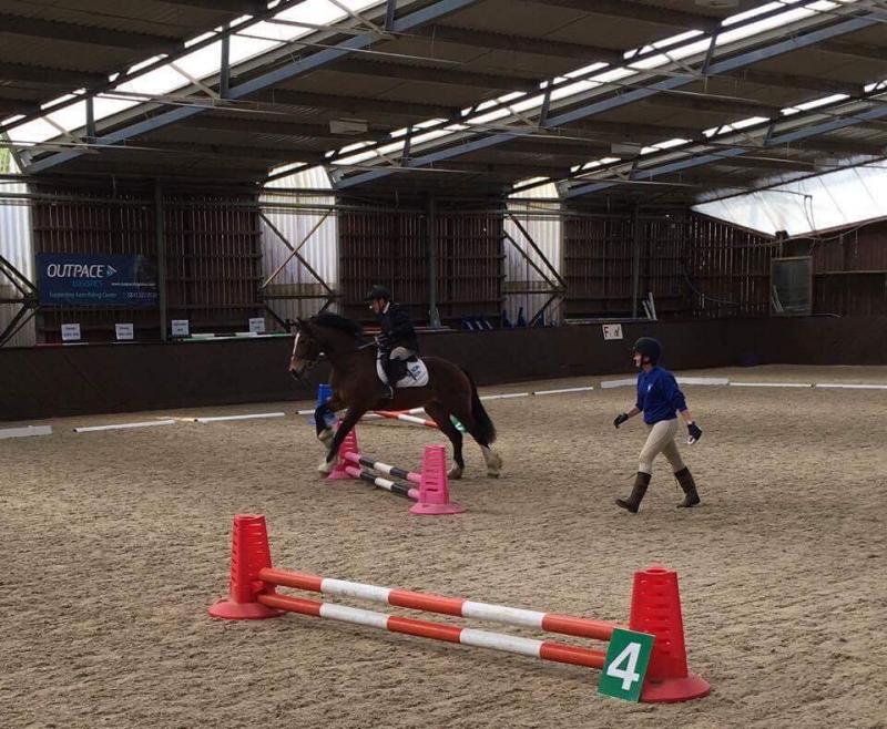 A Downs Syndrome rider going over a jump during a competition