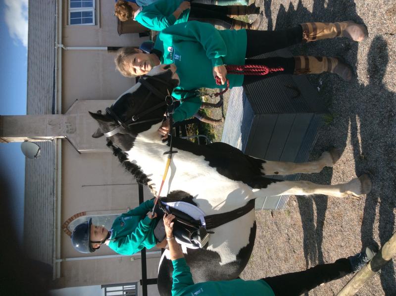 young boy on horse with instructor next to him