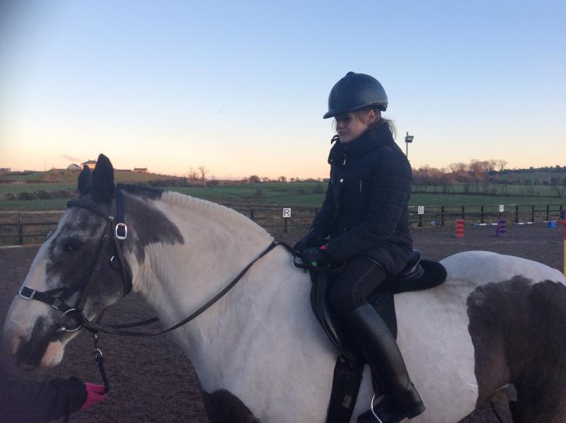 young girl riding a horse at dusk