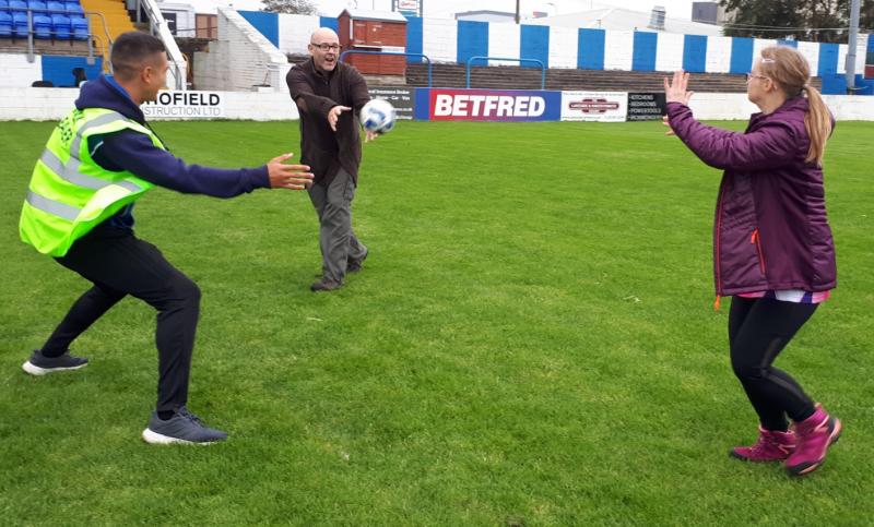 Picture of an Able Raider and her carer, in action, on the rugby field. 