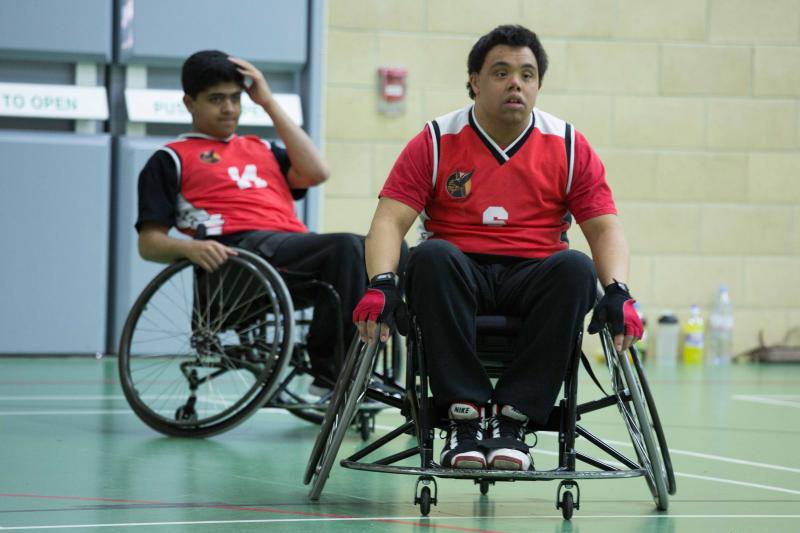 Two wheelchair basketball players moving across the court. 