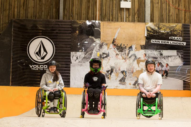 3 WCMX riders on top of the wooden ramps in the indoor skatepark