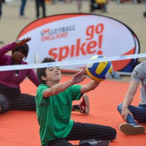 young people playing sitting volleyball