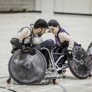Two wheelchair rugby players face off