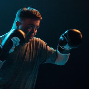 Person in a boxing stance wearing gloves
