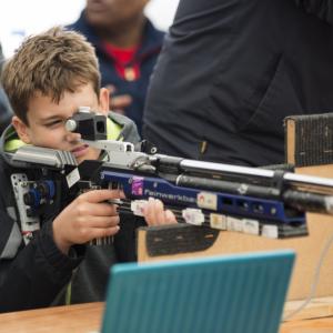 a boy tries shooting on a rifle range