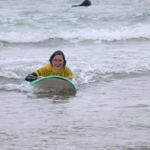 Young person on a surfboard smiling