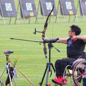 Man in a wheelchair doing archery about to shoot
