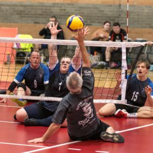 Two teams playing sitting volleyball