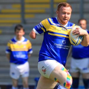 A physical disability rugby league player running with the ball