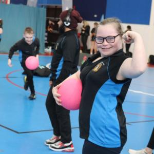 A girl in a netball session showing off her strength by flexing her bicep