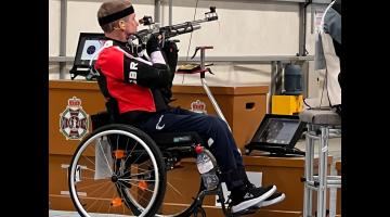 Paul Barker sat in his wheelchair aiming his rifle at a target.