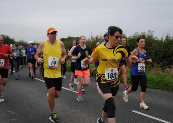 Nicola Fowler running wearing a yellow and black top