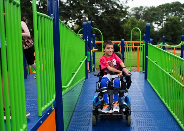 A boy in a wheelchair using an accessible climbing frame