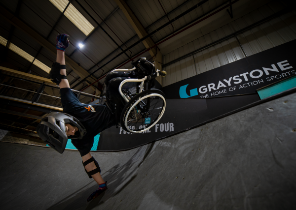 Tomas Woods performs a handplant trick on the side of a steep bank at Graystone Sports Club 