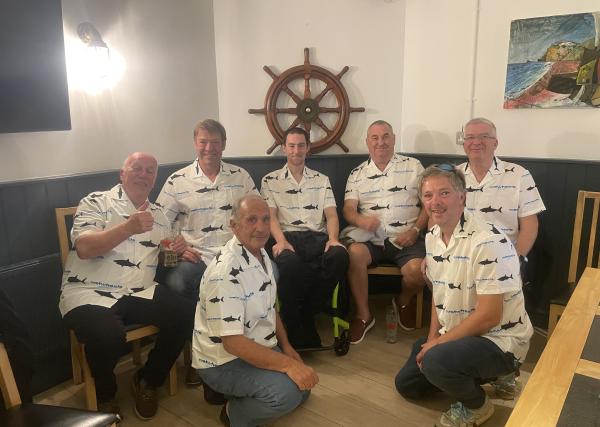 Luke Louden sat in the middle of a group, all looking at the camera and wearing white t-shirts