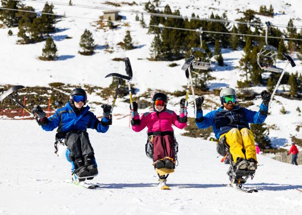 3 sit skiers positioned side by side on a flat slope in the mountains