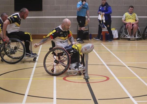 Stewart Walker starts a wheelchair rugby league game by punching the ball off the tee