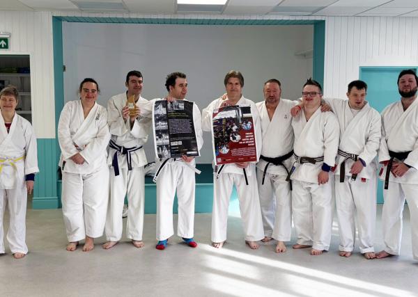 Inclusive karate class, with participant all dressed in their fighting Gis and stood in a row together.