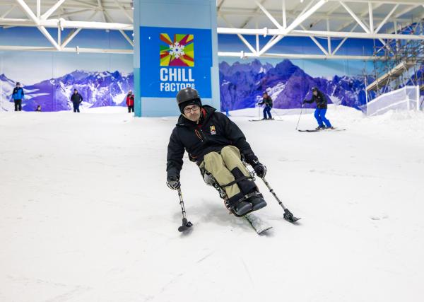 Sit skier, mid run on an indoor snow slope