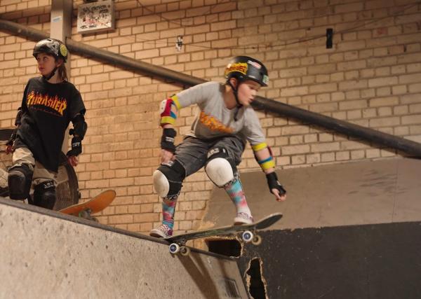 Adaptive skateboarder ready to drop in on an indoor bowl.